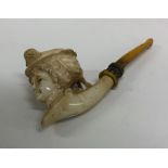 A finely carved amber mounted pipe depicting a lad