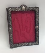 An embossed silver picture frame decorated with sc