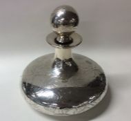 A circular silver and glass overlaid scent bottle