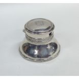 A circular hinged top capstan shaped inkwell toget