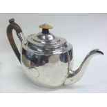 A large plain oval Georgian silver teapot. London.