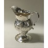 A Georgian silver cream jug with scroll decoration