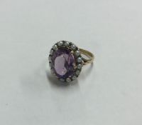 An amethyst and pearl cluster ring in gold claw mo