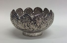 An Indian silver bowl with shaped rim mounted with