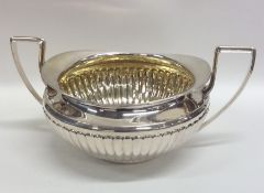 A heavy silver and silver gilt half fluted sugar b