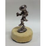 A silver figure of a dancing man on velvet base. A