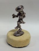 A silver figure of a dancing man on velvet base. A