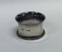 A heavy silver napkin ring decorated with flowers