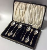 A boxed set of six silver coffee spoons and tongs.