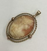A 9 carat oval cameo pendant depicting a lady in g