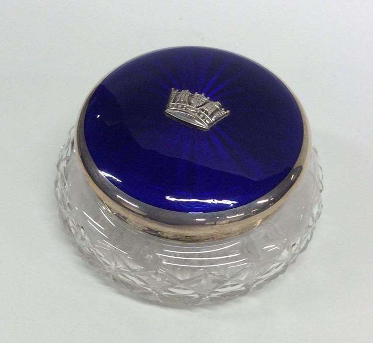 A circular silver and enamelled dressing table box