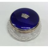 A circular silver and enamelled dressing table box