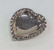 A small silver heart shaped sweet dish with crimpe