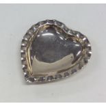 A small silver heart shaped sweet dish with crimpe