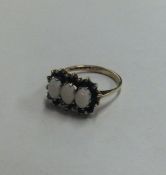 An opal and sapphire triple cluster ring in 9 cara