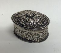 An oval silver embossed box with floral decoration