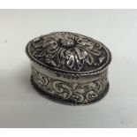 An oval silver embossed box with floral decoration