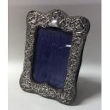 A silver embossed picture frame with velvet back.