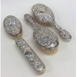 A silver embossed four piece dressing table set. B