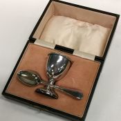 A cased silver egg cup together with a spoon. Shef