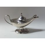 A novelty silver Aladdin's lamp lighter on oval ba