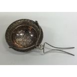 A Continental silver tea strainer with floral deco