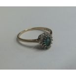 An attractive emerald and diamond cluster ring in