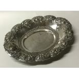 An oval Indian embossed silver dish decorated with