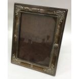 A large silver picture frame decorated with scroll