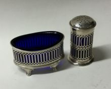 A silver salt and pepper with pierced decoration.