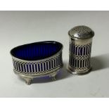 A silver salt and pepper with pierced decoration.