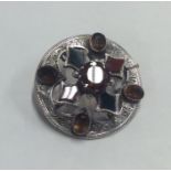 A circular silver and agate brooch in claw mount.