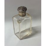 An Edwardian silver mounted dressing table bottle