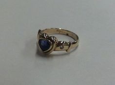 A diamond and blue stone heart shaped ring in 14 c