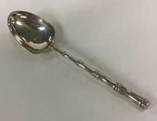 A silver dessert spoon with bamboo design handle.
