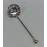 A small silver sifter spoon with pierced bowl. She