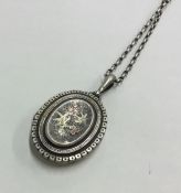 A heavy oval silver locket on chain. Approx. 31.4