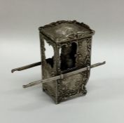 An unusual silver sedan chair attractively decorat