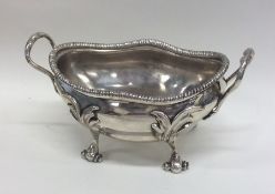 A George III silver butter dish on scroll feet wit