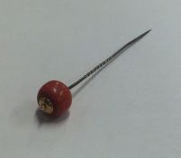 An Antique coral stick pin with gold mount. Approx