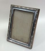 A rectangular silver mounted picture frame on oak