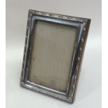 A rectangular silver mounted picture frame on oak