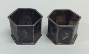 A pair of unusual Niello napkin rings decorated wi