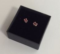 A pair of pink tourmaline ear studs in claw mounts