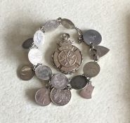 A silver charm bracelet together with a medallion.