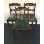 A set of three brass inlaid sabre leg chairs with