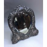 An Edwardian silver heart shaped mirror decorated