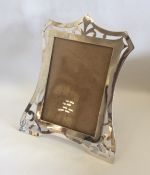 An unusual shaped silver picture frame on spreadin