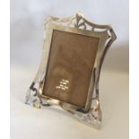 An unusual shaped silver picture frame on spreadin