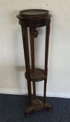 A late Victorian mahogany plant stand with brass m